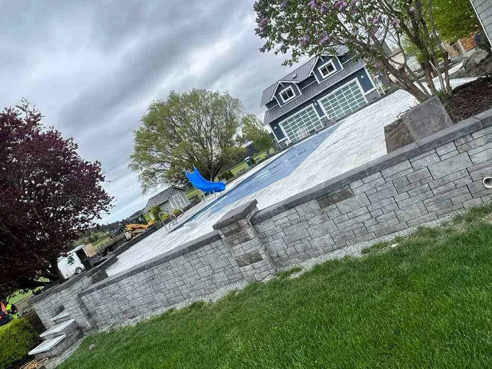 Pool surround with retaining wall
